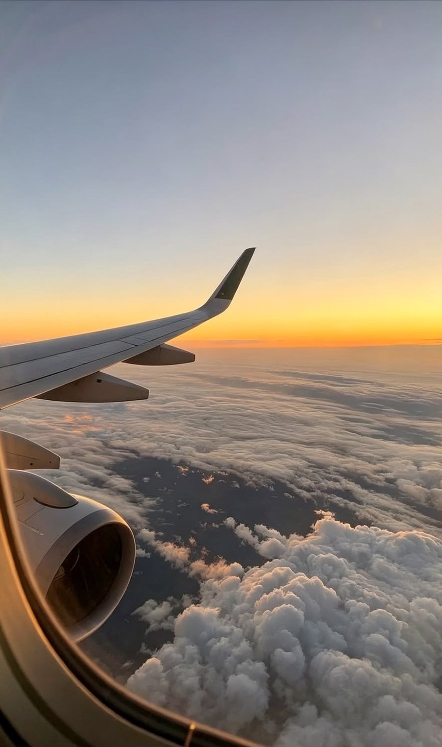 A wing over the clouds at sunset.